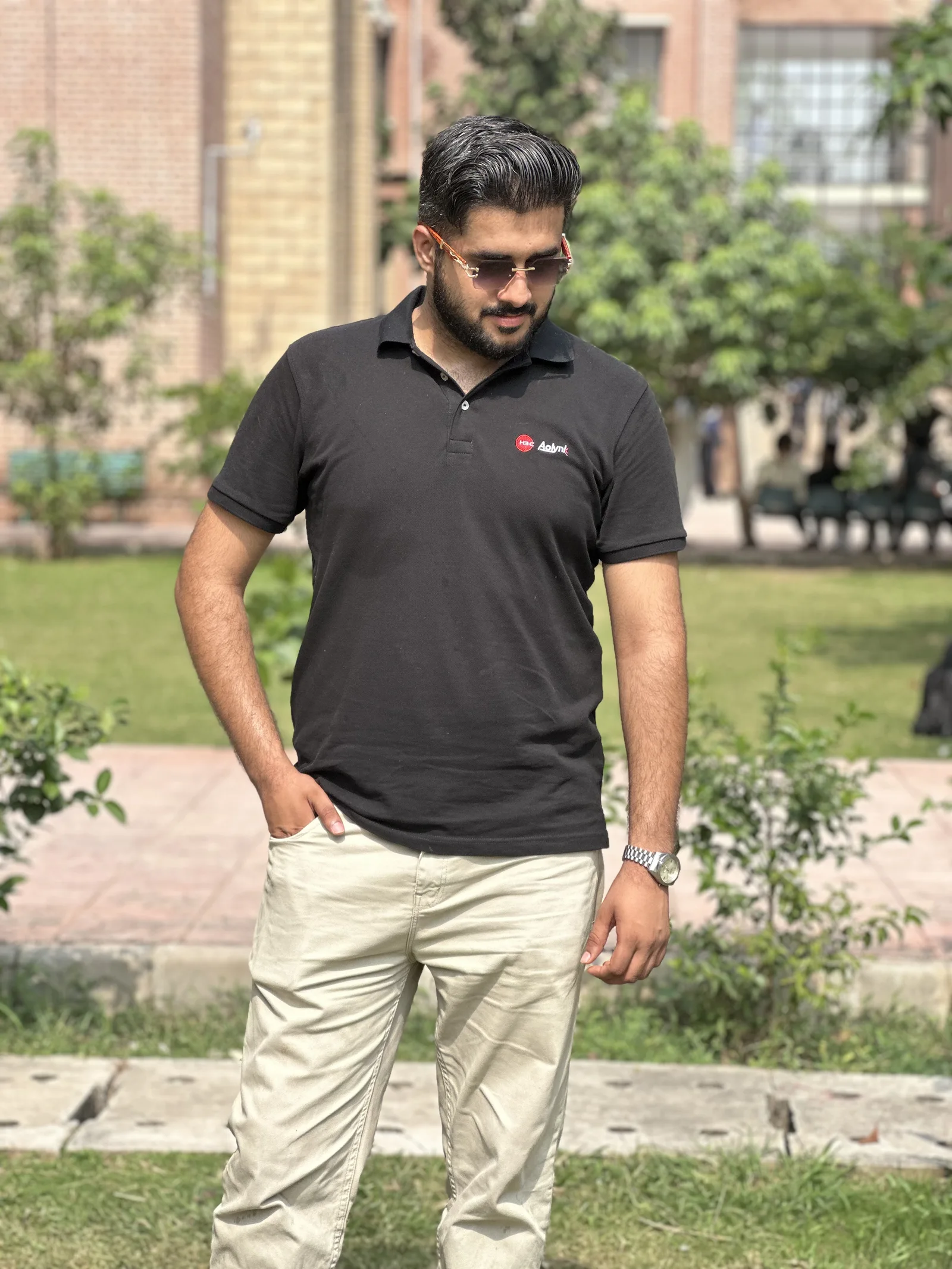 Personal outdoor portrait of Ahmed looking down while standing in a garden